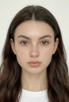 Woman with long brown hair and natural makeup against a white background