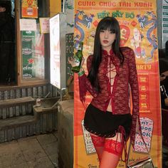Woman in a red lace top and mini skirt holding a beer bottle outdoors at night