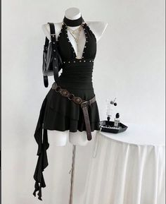 Black halter dress with studded details and a brown belt on a mannequin