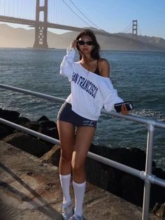 Woman in an off-shoulder top and shorts posing by the Golden Gate Bridge
