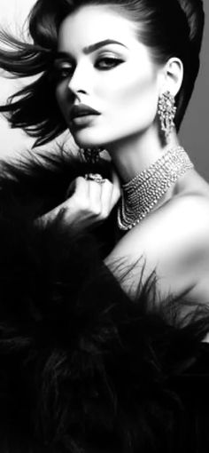 Woman in a fur coat and jewelry in a dramatic black and white portrait