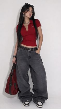 Woman with long dark hair wearing a red polo shirt and baggy jeans
