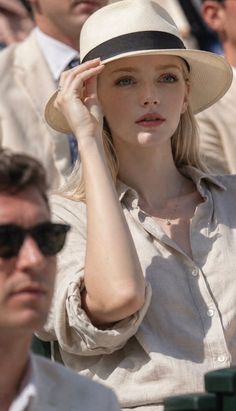 Blonde woman in a straw hat and linen shirt outdoors