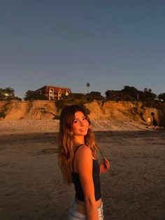 Young woman with long hair on a beach at sunset