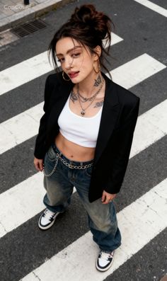 Woman in a crop top and baggy jeans on a crosswalk with a provocative pose