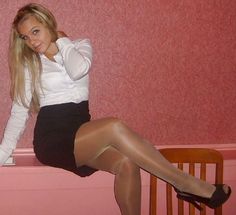 Woman in a white shirt and black skirt with pantyhose and high heels