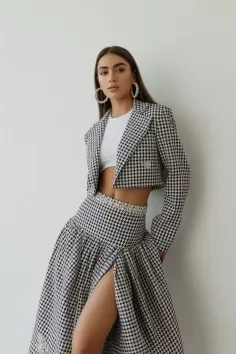 Woman in a houndstooth cropped jacket and long skirt with a high slit