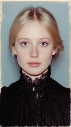 Young woman with blonde hair and blue eyes wearing a black lace collar