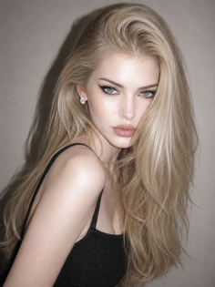 Woman with long blonde hair and blue eyes wearing a black top