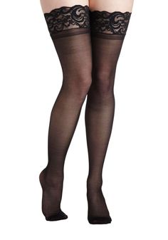 Pair of legs wearing black sheer thigh-high stockings with lace trim