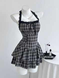 Plaid halter neck dress with lace trim and ruffle skirt on a mannequin