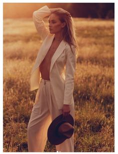 Woman in a white blazer and pants in a field at golden hour