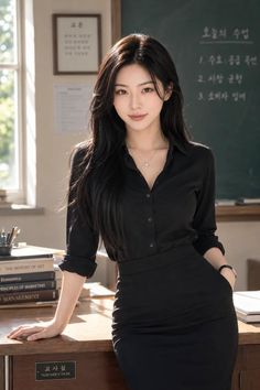 Woman with long black hair in a black shirt and pencil skirt in a classroom