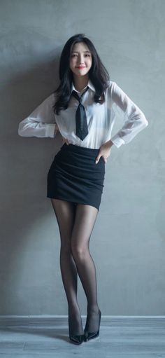 Woman in a white shirt, black tie, mini skirt, and pantyhose posing indoors