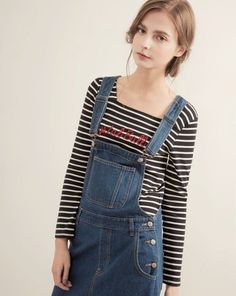 Woman in denim overalls and a striped long-sleeve shirt