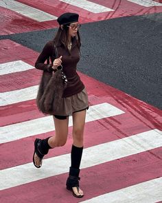 Woman in a beret and mini skirt walking on a crosswalk