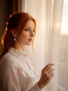 Woman with red hair and blue eyes looking out a window with soft backlight