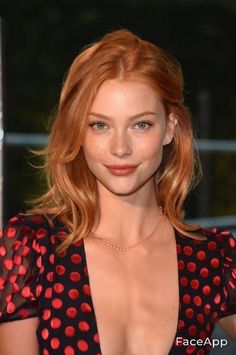 Woman with red hair in a black and red polka dot dress with a deep V-neck