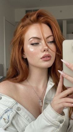 Woman with red hair and freckles wearing a denim jacket and crystal necklace