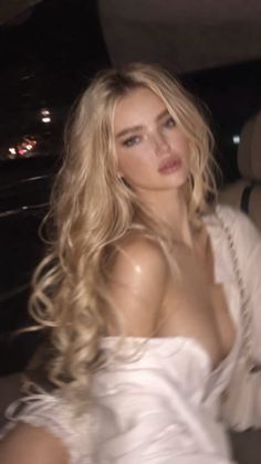 Blonde woman with long wavy hair in a low-cut top at night