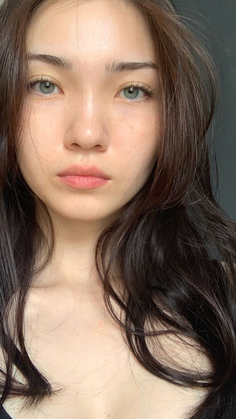 Close up portrait of a woman with long dark hair and green eyes