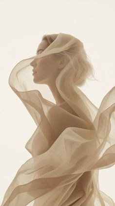 Woman with blonde hair and flowing sheer fabric in soft lighting