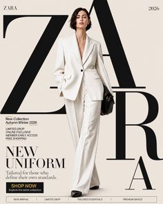 Woman in a white suit holding a black handbag in a studio setting