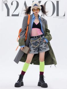 Woman in a shark beanie, oversized coat, and camouflage shorts with a pink fishnet top