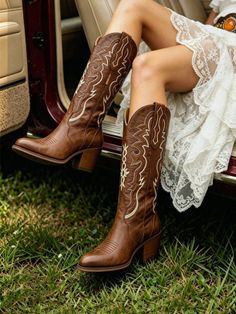 Woman in brown cowboy boots and a white lace dress with exposed legs