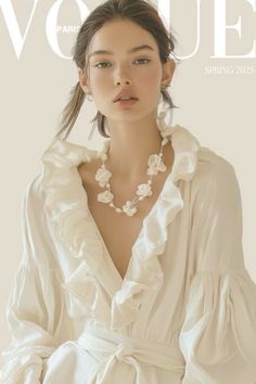 Woman in a white ruffled dress and floral necklace on a magazine cover