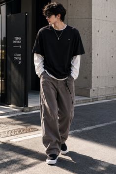 Person with long hair and sunglasses wearing an oversized t-shirt and cargo pants on a street
