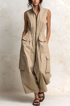 Woman in a beige sleeveless jumpsuit with cargo pockets and sandals