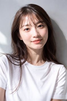 Woman with long hair wearing a white t-shirt, illuminated by soft natural light
