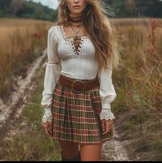 Woman with long hair in a plaid skirt and white blouse walking in a field