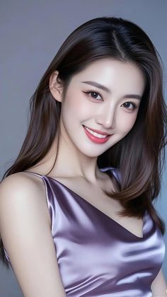Woman with long brown hair wearing a purple dress, smiling at the camera