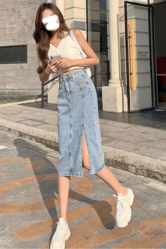 Woman in a denim skirt and white top walking outdoors