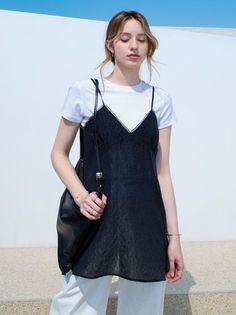 Woman in a black slip dress over a white t-shirt outdoors
