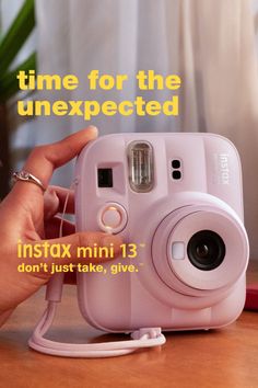 Hand holding a pink instant camera with text overlay