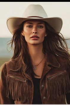 Woman in a cowboy hat and suede fringe jacket outdoors