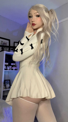 Woman with blonde hair and a mini skirt posing indoors