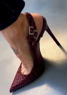 Close up of a foot in a red textured high heel with an ankle strap