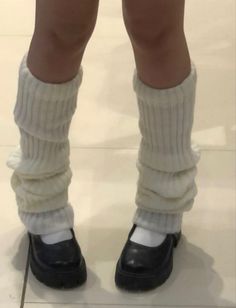 Person wearing white leg warmers and black Mary Jane shoes