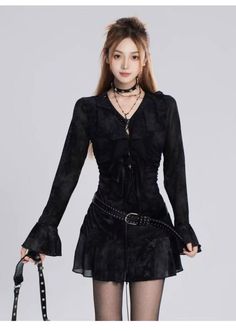 Woman in a black dress with a studded belt and choker in a studio shot