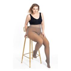 Plus size woman in a black bra and tights sitting on a stool