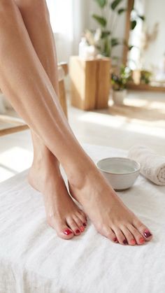 Close up of legs and feet with painted toenails on a white towel