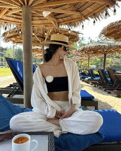 Woman in a straw hat and sunglasses sitting on a beach lounge chair