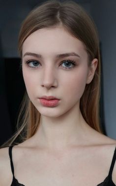 Young woman with long blonde hair and blue eyes in a black top