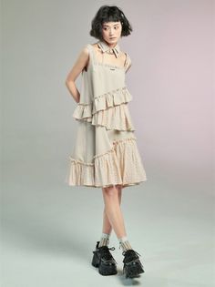 Woman with short hair wearing a ruffled dress and platform shoes