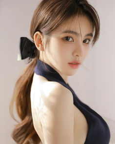 Woman with a ponytail and black bow wearing a halter top with exposed skin