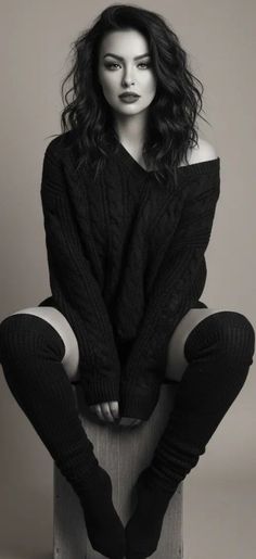 Woman in an off-shoulder sweater and thigh-high socks in a studio shot